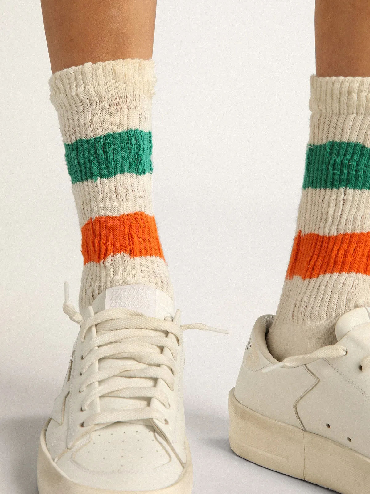 Distressed-finish white socks with green and orange stripes