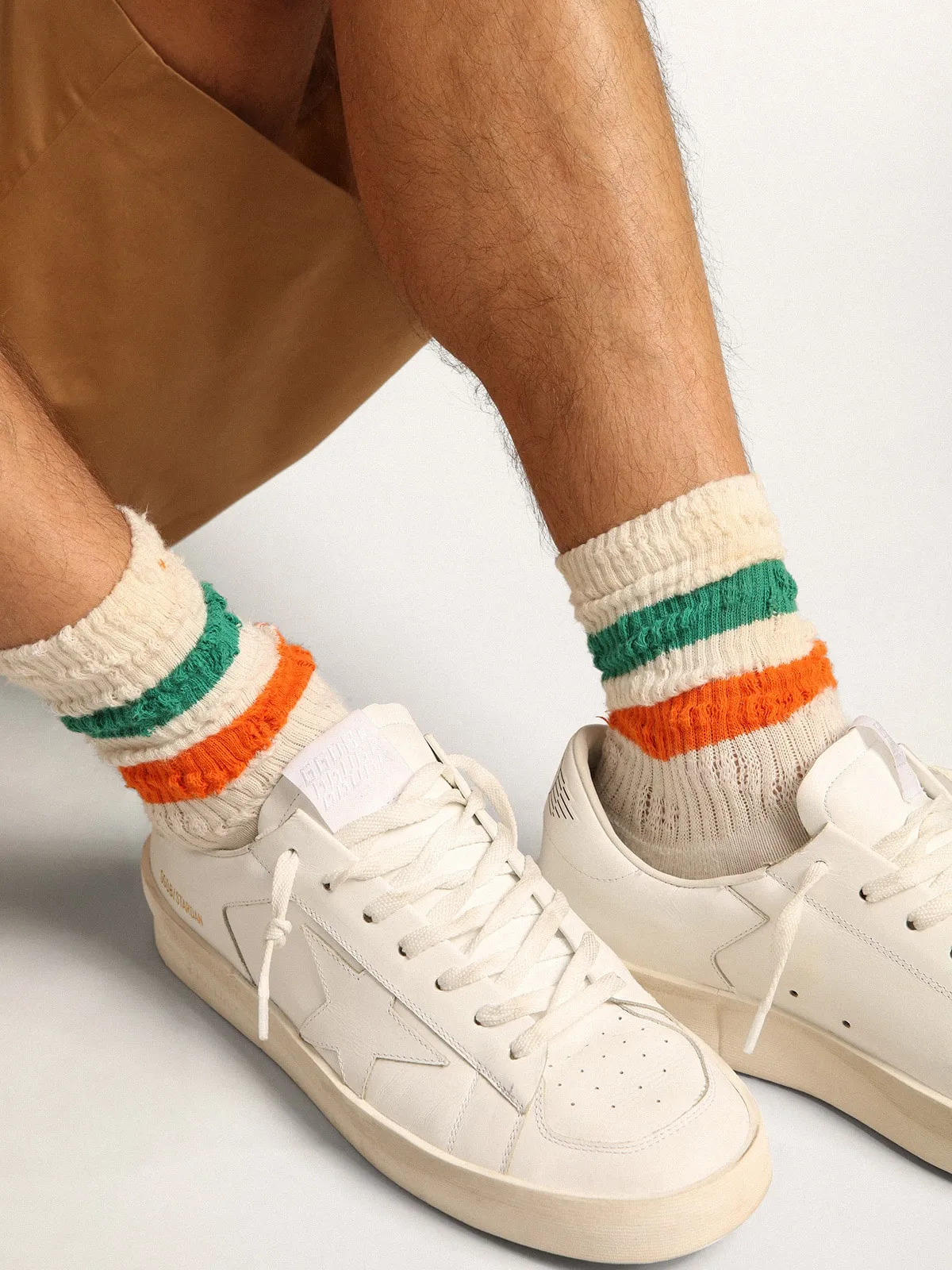 Distressed-finish white socks with green and orange stripes